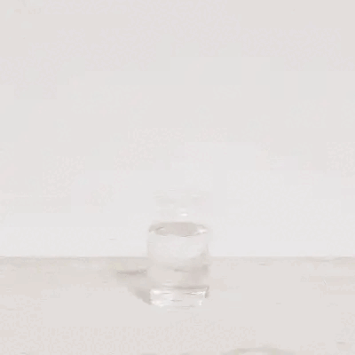 LiquidCalm liquid calm raspberry lemonade powder being poured from a sachet into a glass of water as an evening ashwagandha ritual.